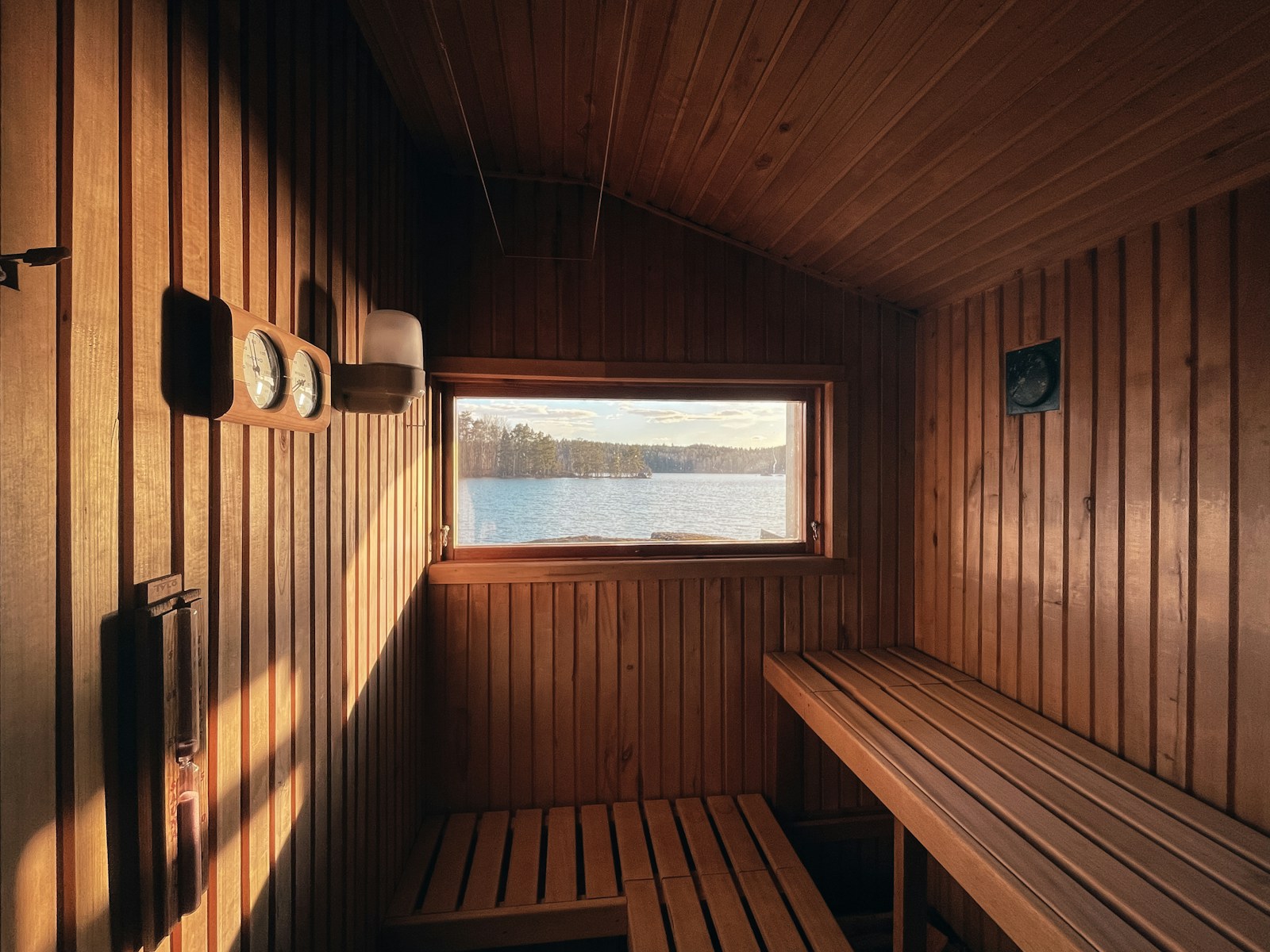 a wooden room with a bench and a window